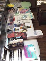 Full view of table with beading supplies, bead containers, design board, and books.