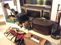 Photo of entire fireplace items on hearth showing two ash cans, wood storage bag, kindling in containers, box, and fireplace tools.