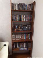 Full view of folding bookshelf loaded with DVDs on five shelves