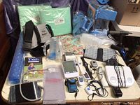 Full overview of the lot, showing assist belts, blue Aquasize exercise equipment, bed pads, medication organizer, and various electronic devices.