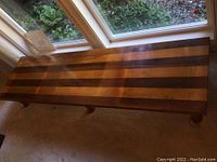 Top-down view showing full length and alternating light and dark wood stripes