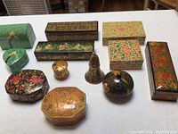 Full assortment showing various hand painted wooden boxes in multiple shapes and sizes along with the candlesticks.
