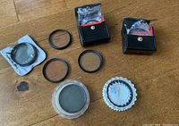 Lot of 52mm diameter circular SLR camera lens filters, some loose some in black boxes and plastic wrapping