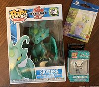 3 brand new toys in boxes including Bakugan Skyress vinyl figure, Pixar Monsters Inc character, and Disney Jack Skellington Funko Pop figure