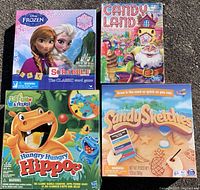 Lot of 4 children's games in box packaging, showing front covers: Frozen Scrabble, Candy Land, Hungry Hungry Hippos, Sandy Sketches