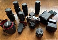 Overhead view of camera body, flash, lenses and cases