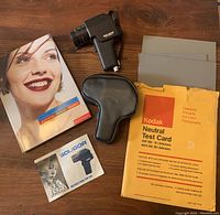 Overview photo showing Kodak Neutral Test Cards envelope, Soligor Spot Sensor light meter with case, instruction booklet, and photography book.