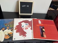 Three LP vinyl records arranged side by side showing the front album covers of The Mills Brothers, Bette Midler, and Nat King Cole.