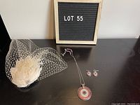 Full set shown with fascinator, necklace with pendant, and matching earrings arranged on a dark surface with LOT 55 sign