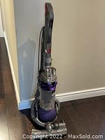 Full assembled vacuum cleaner upright against wall