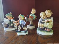 Front view of four Hummel figurines of children in different poses