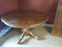 Round solid wood table with pedestal base shown fully assembled