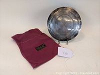 Plaque displayed with red velvet pouch on flat surface, showing overall lot contents.