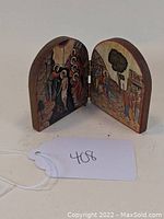 Double panel painted wooden religious icon showing biblical scenes, hinged and standing partially open to display both panels.