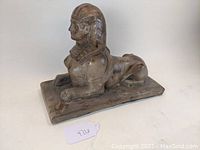 Front side view of the pottery sphinx statue showing detailed facial features and headdress.