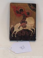 Front view of hand-painted icon of St. George on horseback with red armor and shield, mounted on wood panel showing minor edge wear