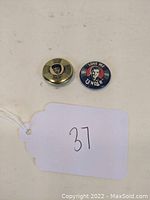 Two vintage Elvis Presley pinback buttons on white background with tag numbered 37.