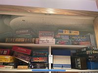 Shelf showing various boxed board games including Pictionary, True Colors, Chicken Soup for the Soul game, 25 Words, and Would You Rather.