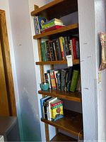 Books arranged on wooden shelves including a mix of classic literature, religious texts, and political books.