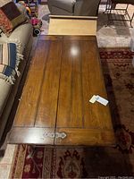 Top view of the wood coffee table showing the plank construction of the top with dark brown wood and metal corner braces.