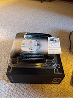 Overview photo of Bose in-ear headphones in packaging on top of Bowers & Wilkins P3 box with Apple earphones visible inside packaging.
