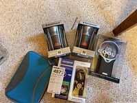 Photo of two Black Diamond Apollo 80 lumens lanterns in packaging, Olympus WS-803 voice recorder, Cool It personal fan and Kindle in blue and gray case.