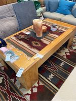 Full view of oak coffee table with woven runner and decorative items on top, highlighting size and style.