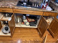 Under-cabinet view showing various pots and pans stored in pull-out drawer