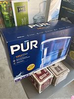 Boxed PUR MaxiON water filter and dispenser with branding and features visible