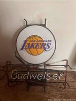 Front view of the neon sign showing round Lakers logo and Budweiser text below, with metal frame.