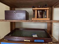 Wooden shelf with dark wooden lockable box and wooden pipe holder with multiple pipes and cleaning tools