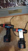Both Skil Warrior cordless power drills with attached batteries viewed from the side and top, showing brand, model, and batteries