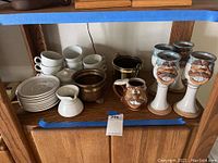 Overall view of the set of Yamaka stoneware cups, saucers, creamer, sugar bowl, Robert Eaton mug, and four decorative wine goblets.