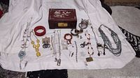 Overview of entire lot showing multiple pieces of jewelry including necklaces, bracelets, earrings, and a decorative box.