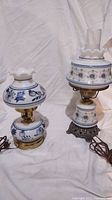 Two vintage style lamps on a white backdrop showing their full form and decorative bases