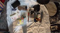 Overview of all items on white sheet including calculators, cards, office supplies, and lamp