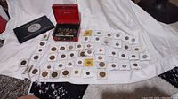 Overview of all items: coin book, cash box with coins, carded coins spread out