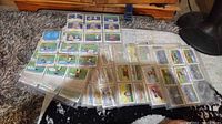 Photo showing a collection of Looney Tunes All Stars trading cards in protective plastic sleeves arranged on carpet.