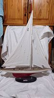 Side view of the Ranger 1937 Jay Yacht model with fully raised white sails and visible rigging on a black base.