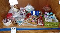 Overview of assorted jewelry making supplies including beads, pliers, necklaces, and packaging on a wooden surface.