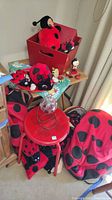 Overview photo showing ladybug plushies, figurines on a red stool, red backpack, and a globe decorative piece.