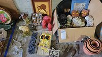 Overview of owl collectibles including candles, figurines, trivets, wall art, and planter pots displayed together.