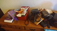 Photo of scarves, belts, wallets, small purse, and pantyhose boxes on wooden drawer surface.