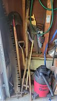 Photo showing several garden tools including a garden row rake, two shovels, a scythe, hand saws, and the 6 gallon Shop Vac at the bottom right.