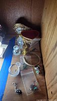 Photo of the decorative brass jewelry box, crystal or glass small statues, and sterling jewelry pieces including rings, bracelet, and pendants.