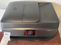 Front and top side view of black HP OfficeJet 5255 printer showing control panel area and paper tray.