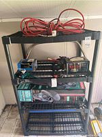 Front angle view of the black plastic shelving unit with various tools and items placed on the shelves.