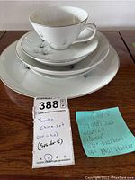 Yamaka China set stacked showing teacup, saucer, small plate and large plate with blue floral design, gold trim, and some chipping visible