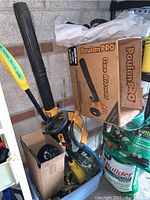 Overall assortment in bin showing blower, box, fertilizers and lights