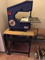 Blue C.I.I. bandsaw model BDS 360S with user manual on table, showing front view with blade and disc sander on left side.